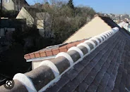 Travaux de finition sur le faîtage d'une toiture